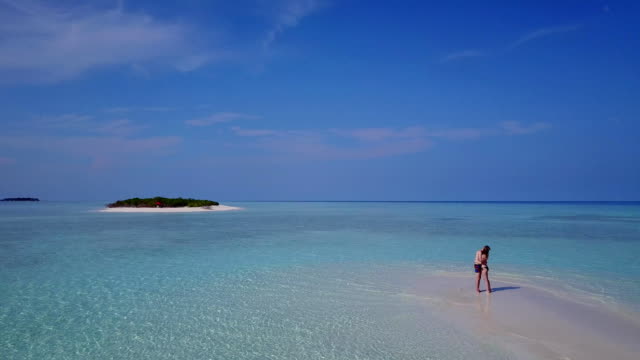 v03878-fliegenden-Drohne-Luftaufnahme-der-Malediven-weißen-Sandstrand-2-Personen-junges-Paar-Mann-Frau-romantische-Liebe-auf-sonnigen-tropischen-Inselparadies-mit-Aqua-blau-Himmel-Meer-Wasser-Ozean-4k