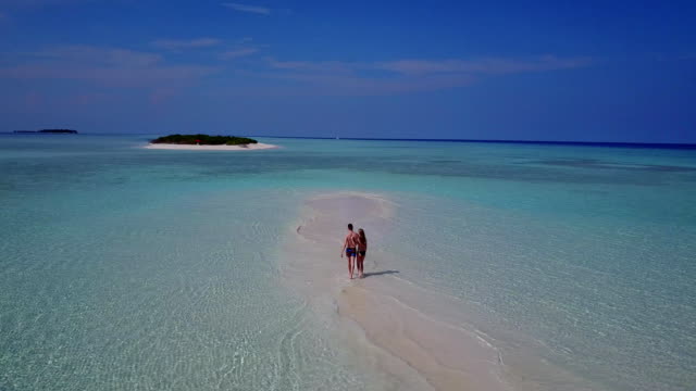 v03994-fliegenden-Drohne-Luftaufnahme-der-Malediven-weißen-Sandstrand-2-Personen-junges-Paar-Mann-Frau-romantische-Liebe-auf-sonnigen-tropischen-Inselparadies-mit-Aqua-blau-Himmel-Meer-Wasser-Ozean-4k