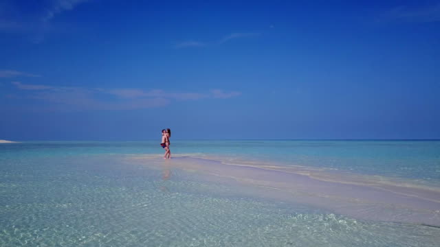 v03893-fliegenden-Drohne-Luftaufnahme-der-Malediven-weißen-Sandstrand-2-Personen-junges-Paar-Mann-Frau-romantische-Liebe-auf-sonnigen-tropischen-Inselparadies-mit-Aqua-blau-Himmel-Meer-Wasser-Ozean-4k
