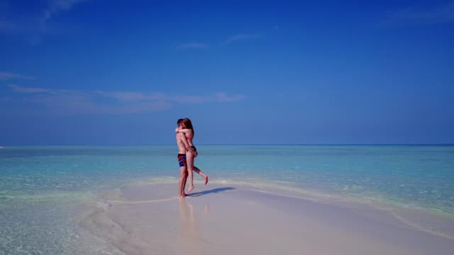 v03907-fliegenden-Drohne-Luftaufnahme-der-Malediven-weißen-Sandstrand-2-Personen-junges-Paar-Mann-Frau-romantische-Liebe-auf-sonnigen-tropischen-Inselparadies-mit-Aqua-blau-Himmel-Meer-Wasser-Ozean-4k