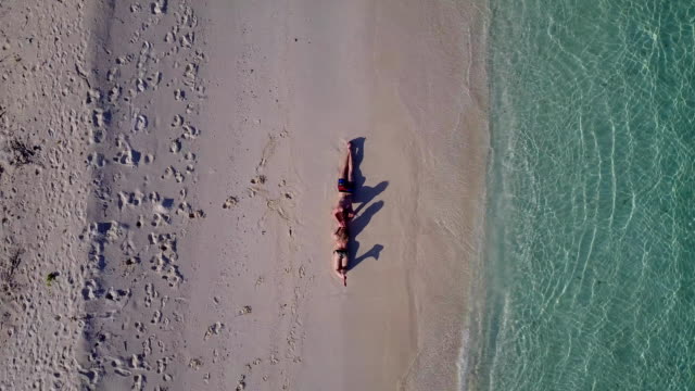 v03890-fliegenden-Drohne-Luftaufnahme-der-Malediven-weißen-Sandstrand-2-Personen-junges-Paar-Mann-Frau-romantische-Liebe-auf-sonnigen-tropischen-Inselparadies-mit-Aqua-blau-Himmel-Meer-Wasser-Ozean-4k