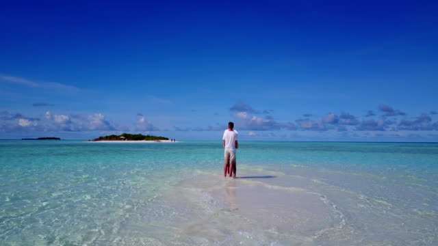 v03943-fliegenden-Drohne-Luftaufnahme-der-Malediven-weißen-Sandstrand-2-Personen-junges-Paar-Mann-Frau-romantische-Liebe-auf-sonnigen-tropischen-Inselparadies-mit-Aqua-blau-Himmel-Meer-Wasser-Ozean-4k