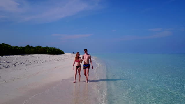 v03873-fliegenden-Drohne-Luftaufnahme-der-Malediven-weißen-Sandstrand-2-Personen-junges-Paar-Mann-Frau-romantische-Liebe-auf-sonnigen-tropischen-Inselparadies-mit-Aqua-blau-Himmel-Meer-Wasser-Ozean-4k