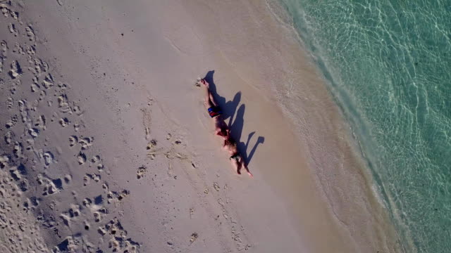 v03998-fliegenden-Drohne-Luftaufnahme-der-Malediven-weißen-Sandstrand-2-Personen-junges-Paar-Mann-Frau-romantische-Liebe-auf-sonnigen-tropischen-Inselparadies-mit-Aqua-blau-Himmel-Meer-Wasser-Ozean-4k