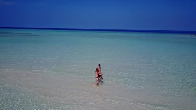 v03876-fliegenden-Drohne-Luftaufnahme-der-Malediven-weißen-Sandstrand-2-Personen-junges-Paar-Mann-Frau-romantische-Liebe-auf-sonnigen-tropischen-Inselparadies-mit-Aqua-blau-Himmel-Meer-Wasser-Ozean-4k