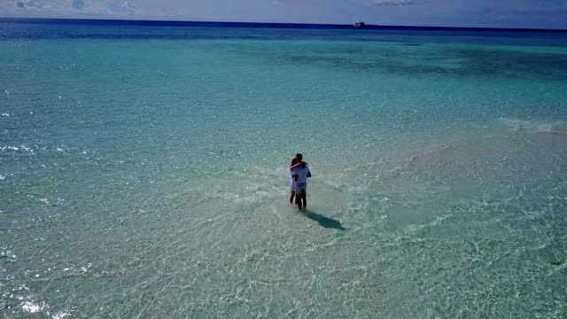 v03923-fliegenden-Drohne-Luftaufnahme-der-Malediven-weißen-Sandstrand-2-Personen-junges-Paar-Mann-Frau-romantische-Liebe-auf-sonnigen-tropischen-Inselparadies-mit-Aqua-blau-Himmel-Meer-Wasser-Ozean-4k