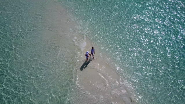v03926-fliegenden-Drohne-Luftaufnahme-der-Malediven-weißen-Sandstrand-2-Personen-junges-Paar-Mann-Frau-romantische-Liebe-auf-sonnigen-tropischen-Inselparadies-mit-Aqua-blau-Himmel-Meer-Wasser-Ozean-4k