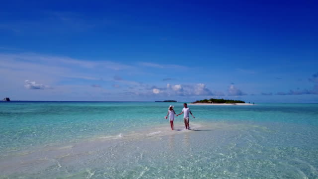 v03945-fliegenden-Drohne-Luftaufnahme-der-Malediven-weißen-Sandstrand-2-Personen-junges-Paar-Mann-Frau-romantische-Liebe-auf-sonnigen-tropischen-Inselparadies-mit-Aqua-blau-Himmel-Meer-Wasser-Ozean-4k