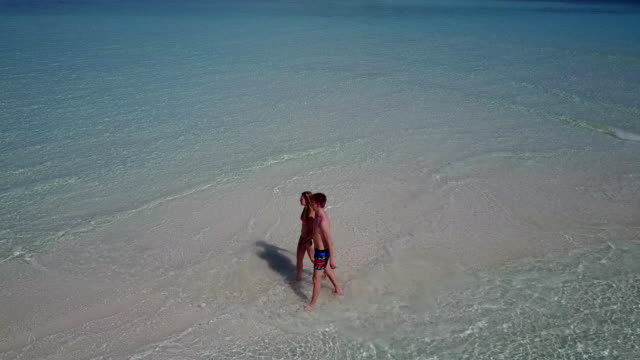 v03874-fliegenden-Drohne-Luftaufnahme-der-Malediven-weißen-Sandstrand-2-Personen-junges-Paar-Mann-Frau-romantische-Liebe-auf-sonnigen-tropischen-Inselparadies-mit-Aqua-blau-Himmel-Meer-Wasser-Ozean-4k