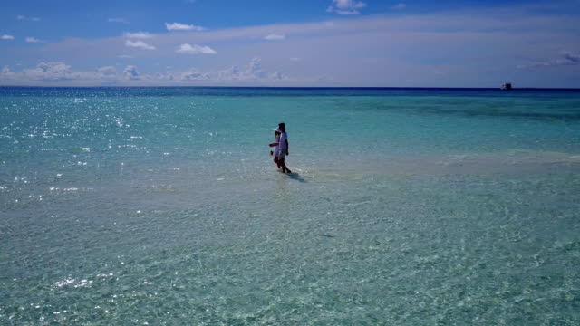 v03911-fliegenden-Drohne-Luftaufnahme-der-Malediven-weißen-Sandstrand-2-Personen-junges-Paar-Mann-Frau-romantische-Liebe-auf-sonnigen-tropischen-Inselparadies-mit-Aqua-blau-Himmel-Meer-Wasser-Ozean-4k