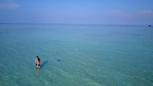 v03976-fliegenden-Drohne-Luftaufnahme-der-Malediven-weißen-Sandstrand-2-Personen-junges-Paar-Mann-Frau-romantische-Liebe-auf-sonnigen-tropischen-Inselparadies-mit-Aqua-blau-Himmel-Meer-Wasser-Ozean-4k