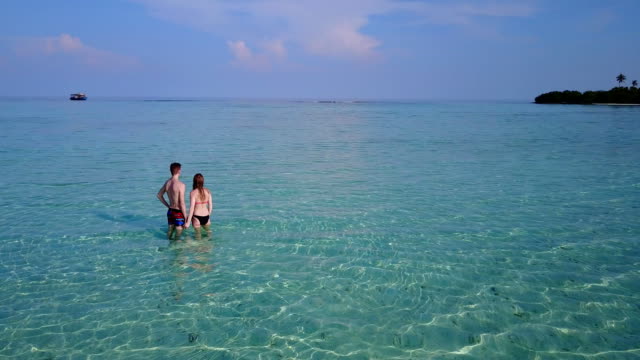v03992-fliegenden-Drohne-Luftaufnahme-der-Malediven-weißen-Sandstrand-2-Personen-junges-Paar-Mann-Frau-romantische-Liebe-auf-sonnigen-tropischen-Inselparadies-mit-Aqua-blau-Himmel-Meer-Wasser-Ozean-4k