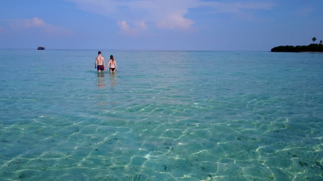 v04039-fliegenden-Drohne-Luftaufnahme-der-Malediven-weißen-Sandstrand-2-Personen-junges-Paar-Mann-Frau-romantische-Liebe-auf-sonnigen-tropischen-Inselparadies-mit-Aqua-blau-Himmel-Meer-Wasser-Ozean-4k