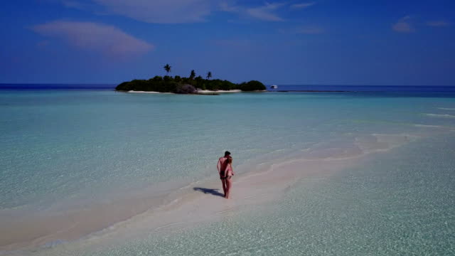 v04001-fliegenden-Drohne-Luftaufnahme-der-Malediven-weißen-Sandstrand-2-Personen-junges-Paar-Mann-Frau-romantische-Liebe-auf-sonnigen-tropischen-Inselparadies-mit-Aqua-blau-Himmel-Meer-Wasser-Ozean-4k