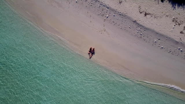 v04021-fliegenden-Drohne-Luftaufnahme-der-Malediven-weißen-Sandstrand-2-Personen-junges-Paar-Mann-Frau-romantische-Liebe-auf-sonnigen-tropischen-Inselparadies-mit-Aqua-blau-Himmel-Meer-Wasser-Ozean-4k