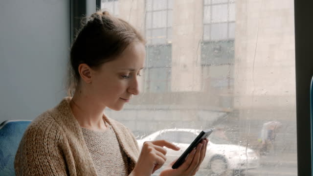 Woman-travelling-by-bus-and-using-smartphone