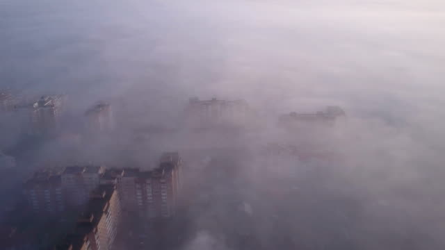 Bajo-vuelo-sobre-la-ciudad-durante-una-niebla-hermosa-mañana.