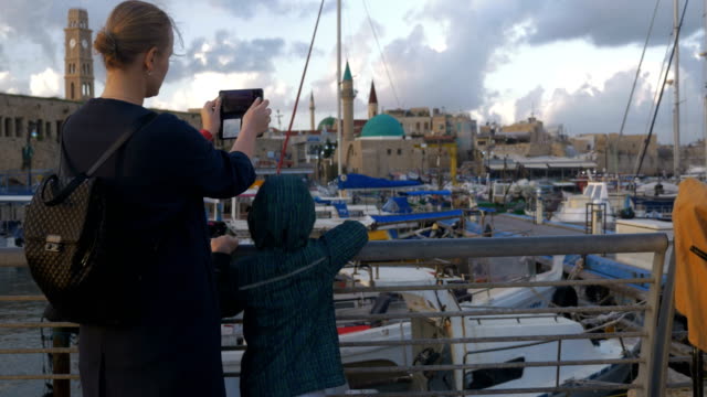 Mujer-con-hijo-tomando-fotos-cuando-visite-Puerto-de-Acre,-Israel