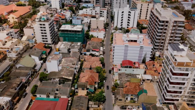 Drone-volando-hacia-atrás-sobre-la-ciudad-de-Colombo,-Sri-Lanka.-Vista-aérea-del-paisaje-asiático-con-edificios-modernos-y-antiguos
