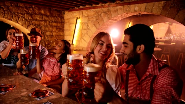 Young-multi-ethnic-couples-and-friends-celebrating-Oktoberfest-at-bar