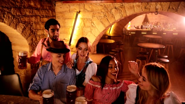 Young-multi-ethnic-friends-celebrating-Oktoberfest-at-Bavarian-bar-party