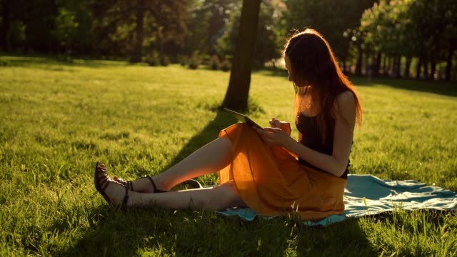 Young-lady-using-tablet-computer-outdoors