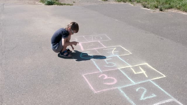 Boy-is-drawing-hopscotch-on-the-asphalt.