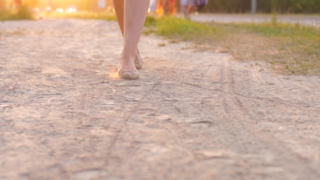 Woman-feet-in-flat-shoes-walk-on-dusty-path