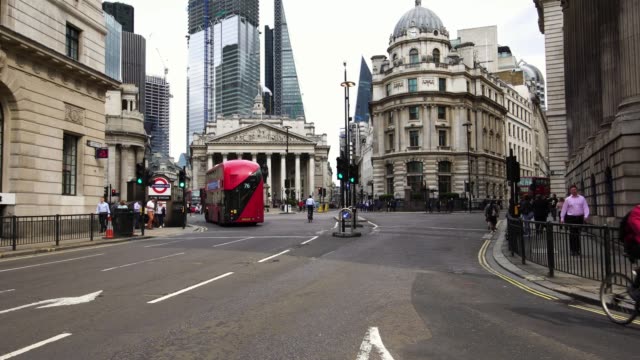 Autobús-rojo-de-dos-pisos-pasando-durante-hora-de-acometidas-de-la-mañana-en-el-distrito-financiero-de-Londres,-Reino-Unido.