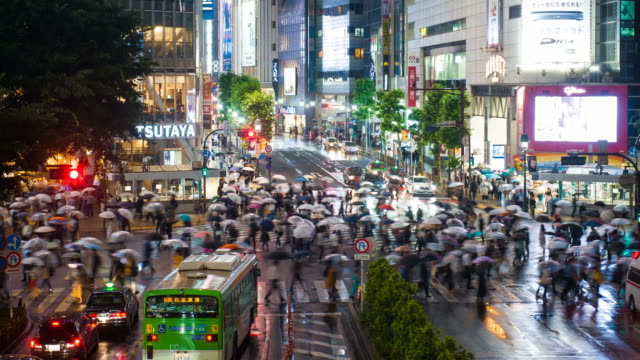 Stadtteil-Shibuya-in-der-regnerischen-Nacht-mit-Publikum-vorbeigehen-Zebrastreifen.-Tokio,-Japan.--4K-Zeitraffer.