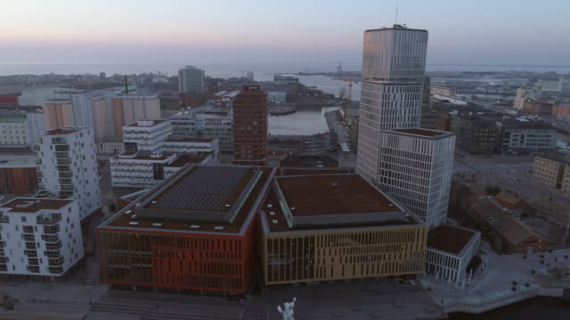 Distrito-financiero-oficina-edificios-vista-aérea-en-Malmö,-Suecia.-Tiro-de-Drone-volando-alrededor-de-edificios-del-negocio-moderno-rascacielos-centro-de-la-ciudad-al-atardecer