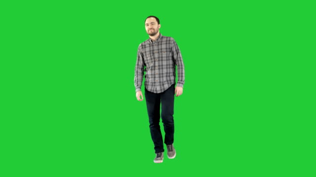 Young-man-walking-in-a-good-mood-on-a-Green-Screen,-Chroma-Key