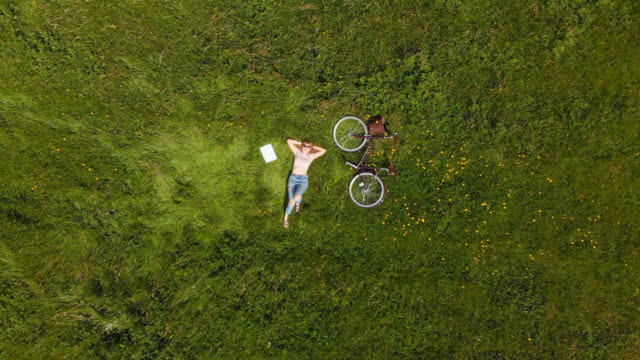 Young-woman-relaxing-in-green-field-4k