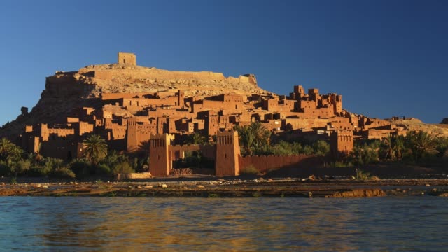 An-einem-strahlenden-sonnigen-Tag-fließt-das-Wasser-in-Ait-Ben-Haddou,-Marokko,-schnell.-Befestigtes-Dorf-(ighrem,-ksar)-auf-der-ehemaligen-Karawanenroute-zwischen-Marrakesch-und-Sahara.-UHD
