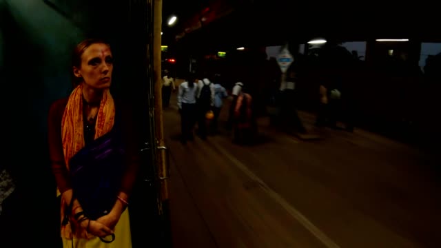 Frau-in-der-Nähe-von-offenen-Türen-in-bewegten-Bahnhof-von-Kalkutta-riesige-Menschenmenge-Abend