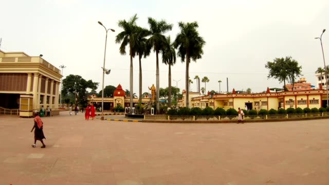 plaza-cerca-de-Kali-Ma-estatua-del-templo-de-Vivekananda-palmeras-peatones-caminan-lentamente-día-nublado-Misión-Ramakrishna