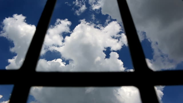 Prison-bars-and-blue-sky,-dolly-shot