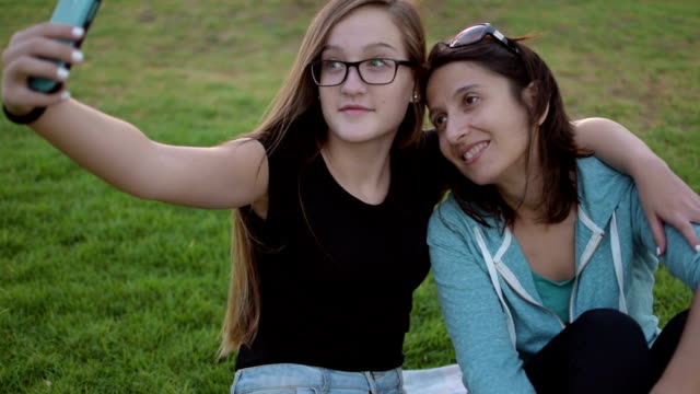 Teenage-girl-with-her-mother-taking-self-ie-in-the-park
