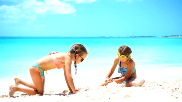 Glückliches-kleines-Mädchen-spielen-mit-Strand-Spielzeug-im-tropischen-Urlaub