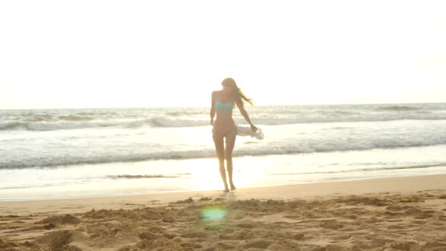 Junge-glücklich-Frau-mit-Schal-von-Ocean-Beach-bei-Sonnenuntergang-entlang-gehen.-Mädchen-genießen-Sommer.-Frau-im-Bikini-mit-fliegenden-Schal-in-Händen-zu-Fuß-am-Ufer-Meeres.-Nahaufnahme