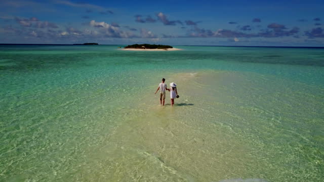 v03906-fliegenden-Drohne-Luftaufnahme-der-Malediven-weißen-Sandstrand-2-Personen-junges-Paar-Mann-Frau-romantische-Liebe-auf-sonnigen-tropischen-Inselparadies-mit-Aqua-blau-Himmel-Meer-Wasser-Ozean-4k