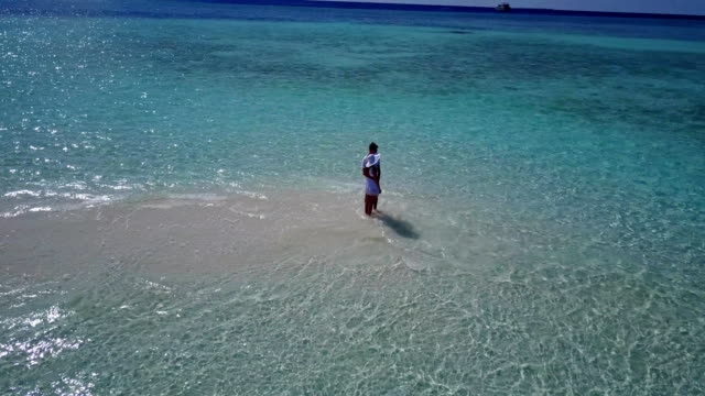 v03928-fliegenden-Drohne-Luftaufnahme-der-Malediven-weißen-Sandstrand-2-Personen-junges-Paar-Mann-Frau-romantische-Liebe-auf-sonnigen-tropischen-Inselparadies-mit-Aqua-blau-Himmel-Meer-Wasser-Ozean-4k