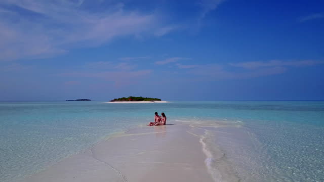 v03995-fliegenden-Drohne-Luftaufnahme-der-Malediven-weißen-Sandstrand-2-Personen-junges-Paar-Mann-Frau-romantische-Liebe-auf-sonnigen-tropischen-Inselparadies-mit-Aqua-blau-Himmel-Meer-Wasser-Ozean-4k