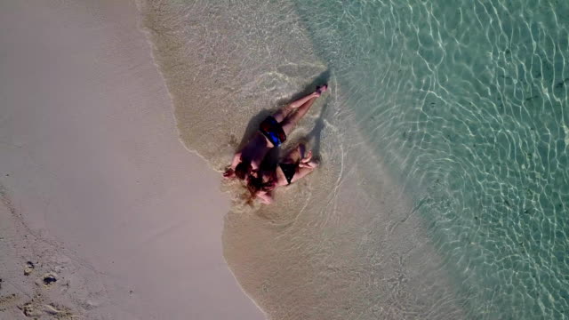 v03897-vuelo-drone-vista-aérea-de-Maldivas-playa-2-personas-pareja-hombre-mujer-amor-romántico-en-la-isla-de-paraíso-tropical-soleado-con-cielo-azul-aqua-agua-mar-4k
