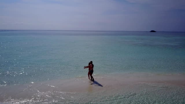v03959-fliegenden-Drohne-Luftaufnahme-der-Malediven-weißen-Sandstrand-2-Personen-junges-Paar-Mann-Frau-romantische-Liebe-auf-sonnigen-tropischen-Inselparadies-mit-Aqua-blau-Himmel-Meer-Wasser-Ozean-4k