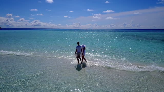 v03920-fliegenden-Drohne-Luftaufnahme-der-Malediven-weißen-Sandstrand-2-Personen-junges-Paar-Mann-Frau-romantische-Liebe-auf-sonnigen-tropischen-Inselparadies-mit-Aqua-blau-Himmel-Meer-Wasser-Ozean-4k