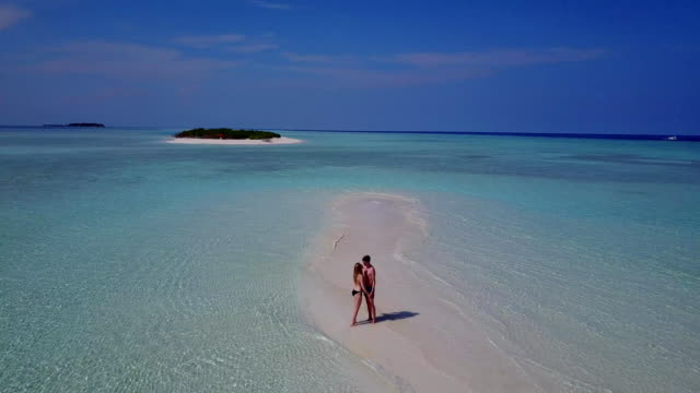 v03958-fliegenden-Drohne-Luftaufnahme-der-Malediven-weißen-Sandstrand-2-Personen-junges-Paar-Mann-Frau-romantische-Liebe-auf-sonnigen-tropischen-Inselparadies-mit-Aqua-blau-Himmel-Meer-Wasser-Ozean-4k