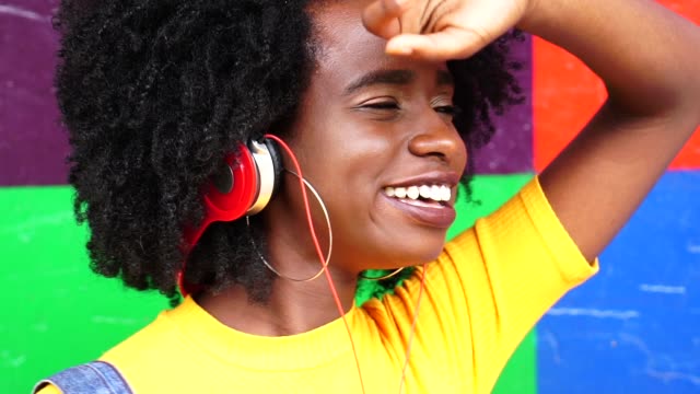 Hübsches-Mädchen-hören-von-Musik-mit-ihrem-Kopfhörer-mit-farbigen-Hintergrund