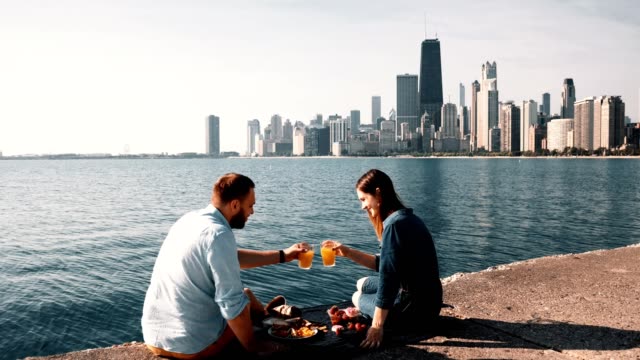 Romantisches-Date-am-Ufer-des-Lake-Michigan-in-Chicago,-Amerika.-Schönes-Paar-genießen-ein-Picknick-zusammen