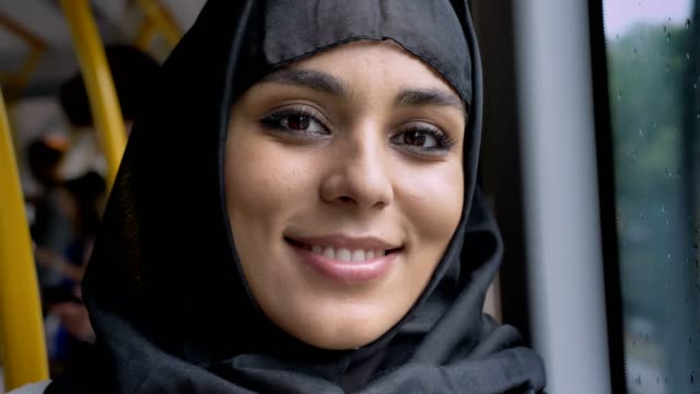 Joven-mujer-musulmana-dulce-en-hijab-está-mirando-a-cámara-en-el-autobús,-concepto-de-transporte,-concepto-urbano,-concepto-de-tiempo,-soñando-con-concepto